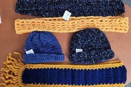 hand knitted and crocheted hats and scarves in blues and golds