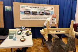 a member of the Morgantown North Rotary makes a wooden friendship bench during the twenty twenty-one Mountaineer Week Arts and Craft Fair
