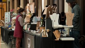 A patron browses the wares at a booth during the 2021 Arts & Craft Fair