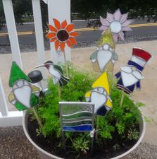 Stained glass yard stakes in the shape of gnomes, sun flowers and birds