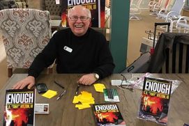 Author Tony Hylton sits at a book signing 