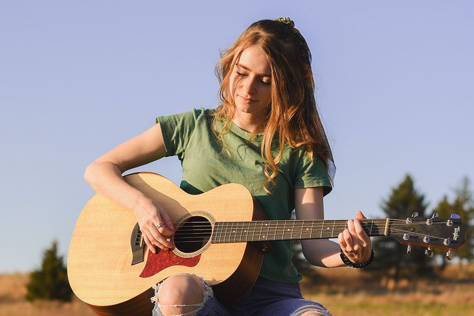 Anna Dunham plays acoustic guitar