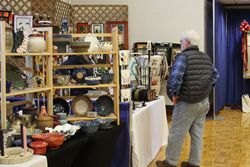 A patron admires the pottery at the booth during the 2023 Mountaineer Week Arts and Craft Fair.
