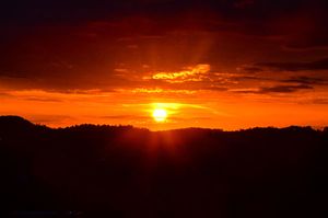 sun setting over the mountains above the Monongahela River
