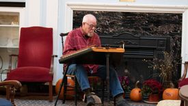 A man plays the dulcimer in the E Moore Hall lounge